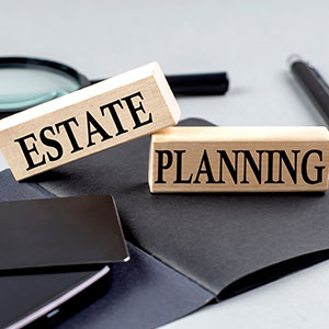 Two wooden blocks spelling out "estate planning" in black lettering.
